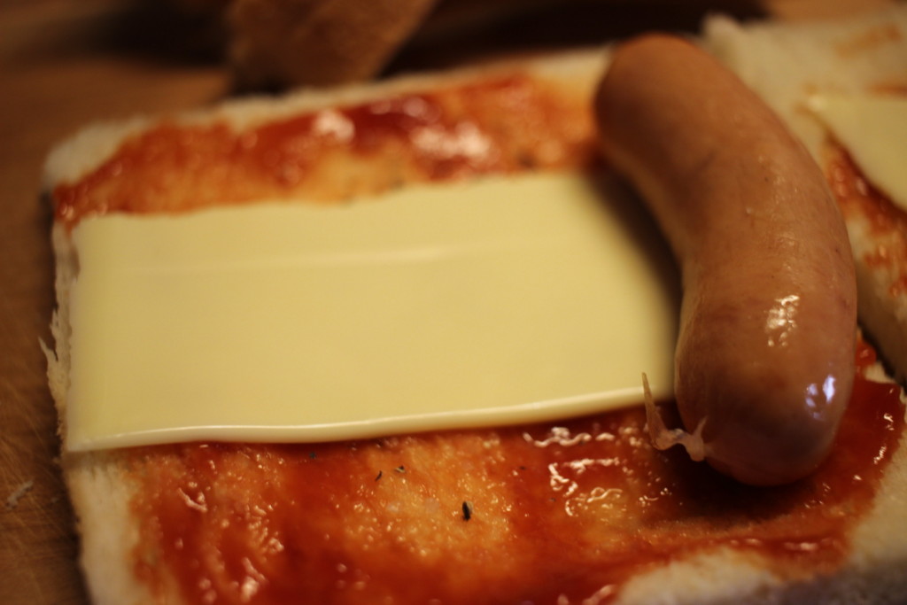 食パンにチーズとソーセージをのせて包んでいるところ